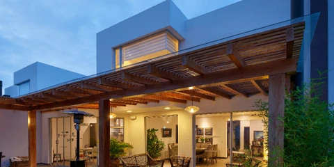Terrasse méditerranéenne avec pergola en bois supportant une bougainvillée aux fleurs violettes luxuriantes