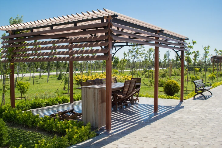 Espace extérieur aménagé avec pergola en bois dans un parc paysager
