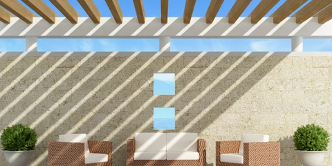 Terrasse extérieure couverte avec pergola en bois, salon de jardin en résine tressée avec coussins colorés rayés, table basse ronde en cuir, coin repas avec chaises