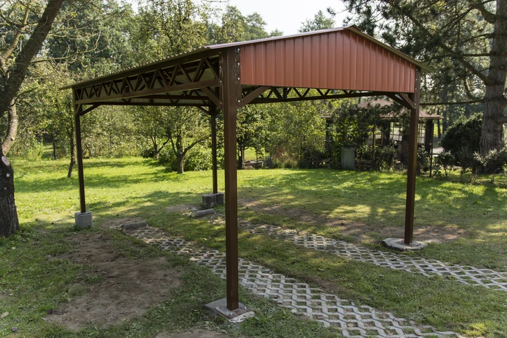 Extérieur résidentiel avec pergola en construction dans jardin arboré