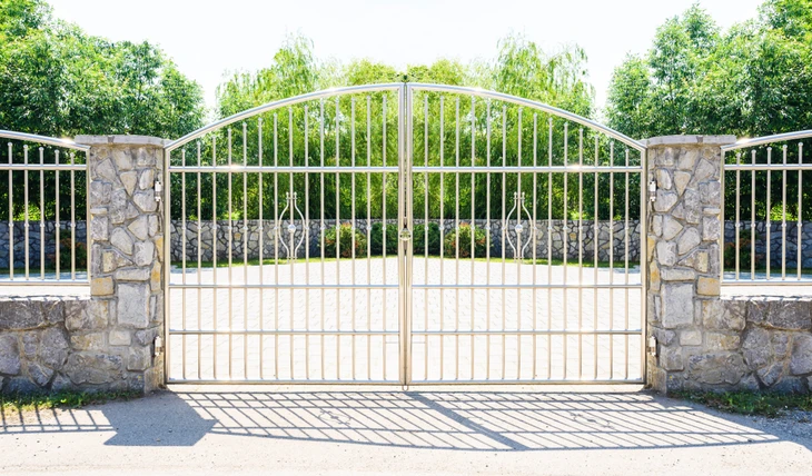 Entrée de propriété avec portail métallique à deux battants de style contemporain, intégrant des barreaux verticaux et motifs décoratifs courbes
