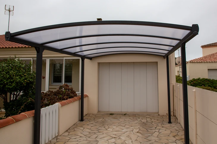 Carportage en polycarbonate sur une maison de garage en façade comme un toit pergola de patio de voiture