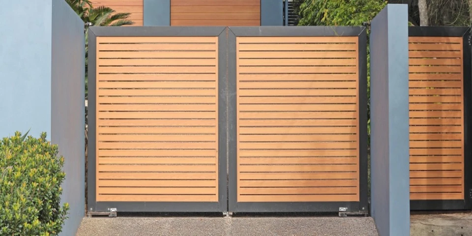 Scène extérieure résidentielle avec véhicule compact noir garé devant portail métallique et façade beige