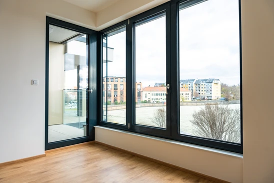 Intérieur moderne avec grandes baies vitrées coulissantes à cadres noirs ouvrant sur terrasse