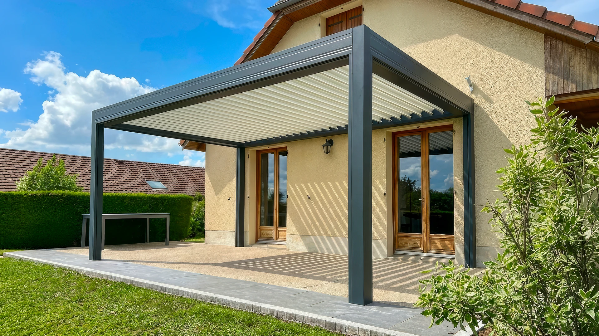 Terrasse couverte résidentielle avec pergola bioclimatique à lames orientables, structure aluminium anthracite